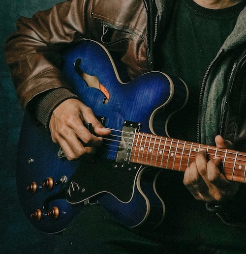 Person playing a blue guitar