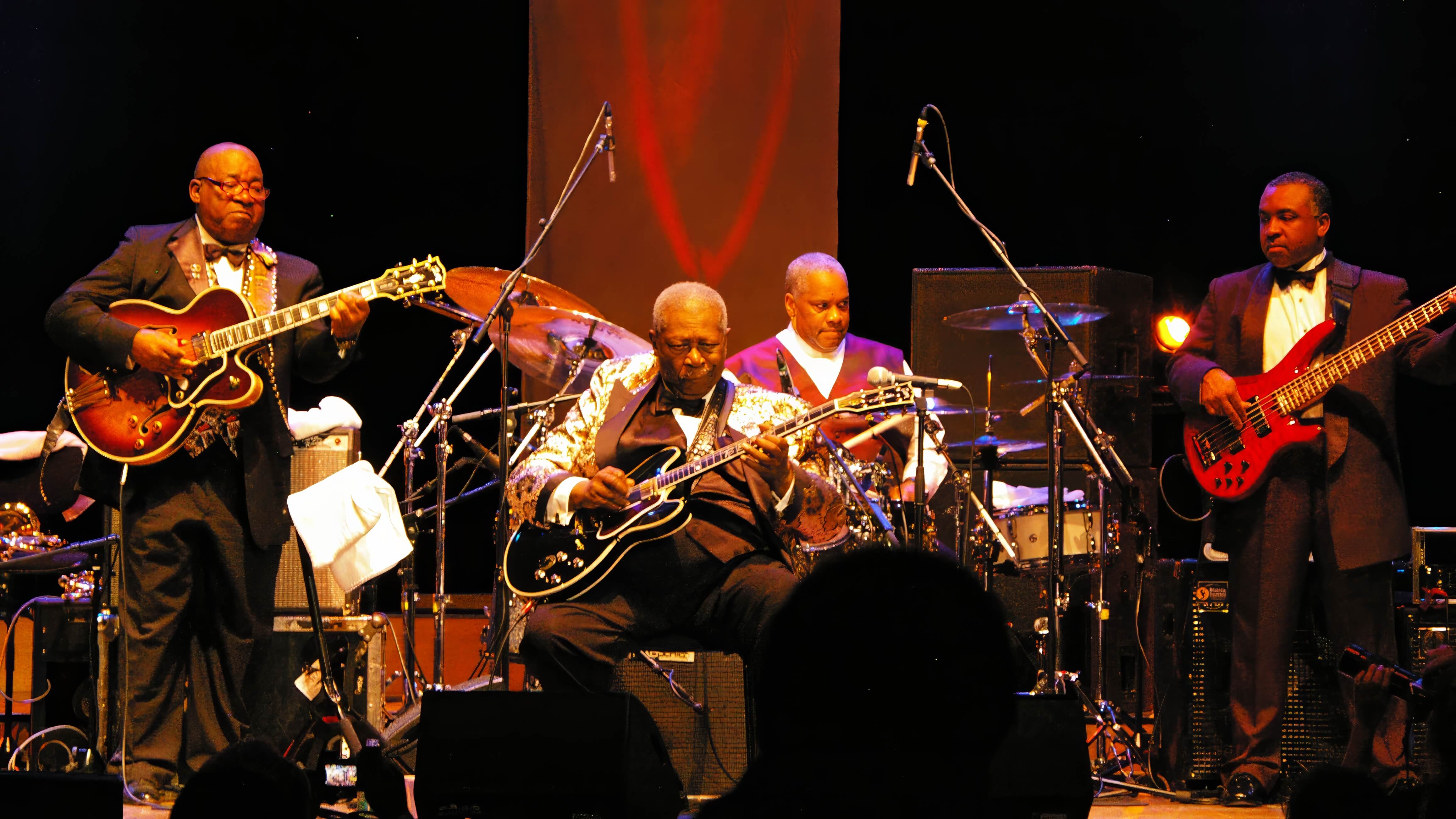 blues artists performing with band on stage