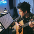 guitar player studying natural harmonics