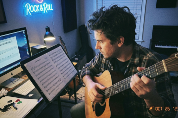 guitar player studying natural harmonics